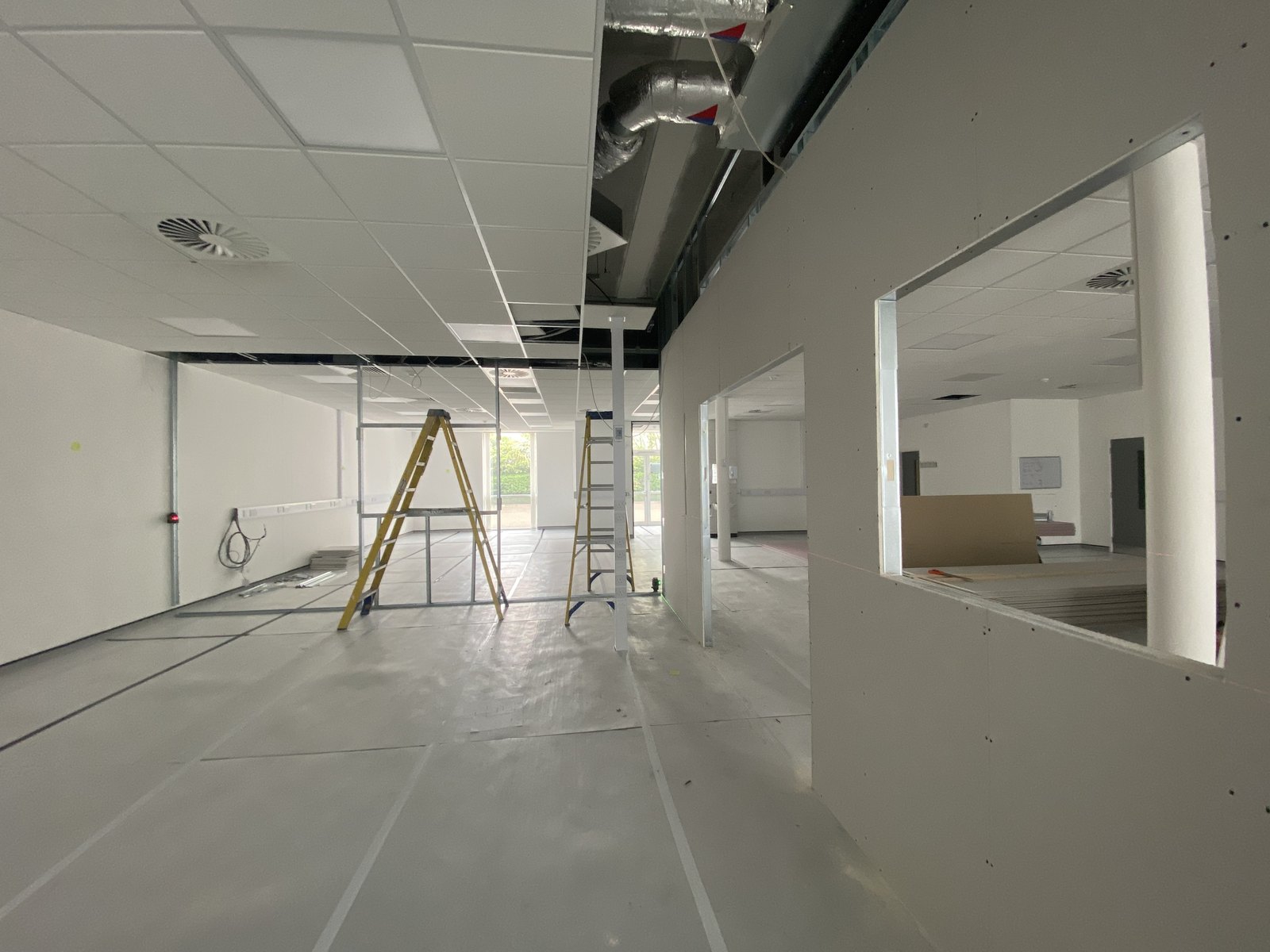 Boarded inspection-room wall at Cambridge Research Park