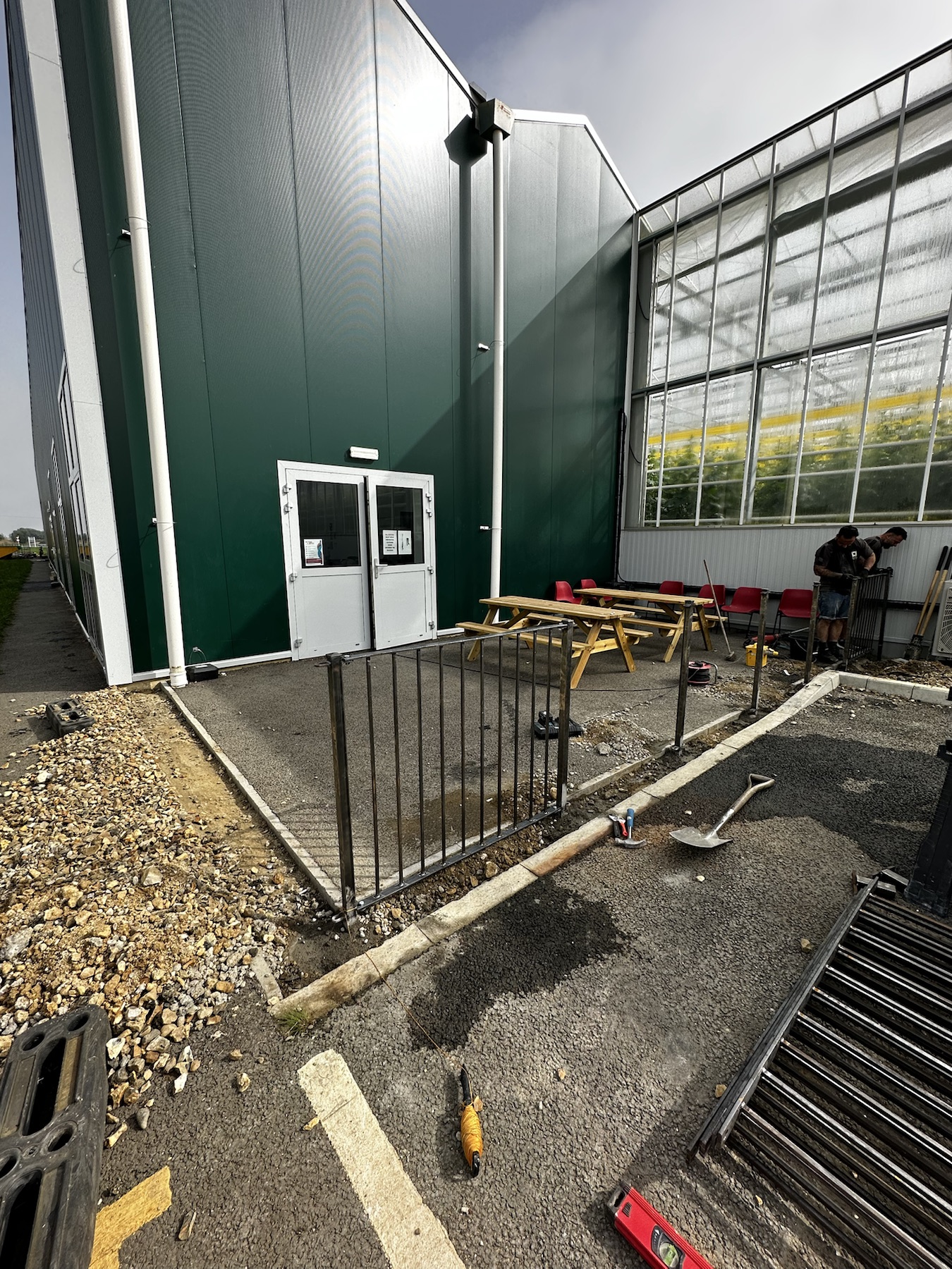 Iron railings being installed around a smoking area in Ely