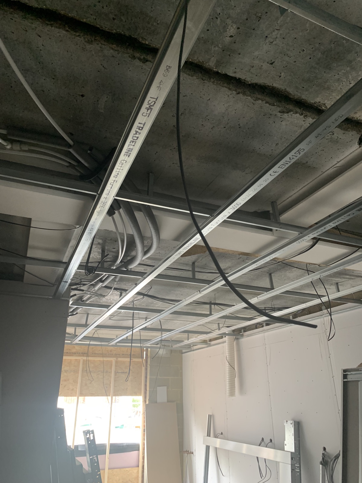 MF ceiling grid installed in a commercial room around existing services