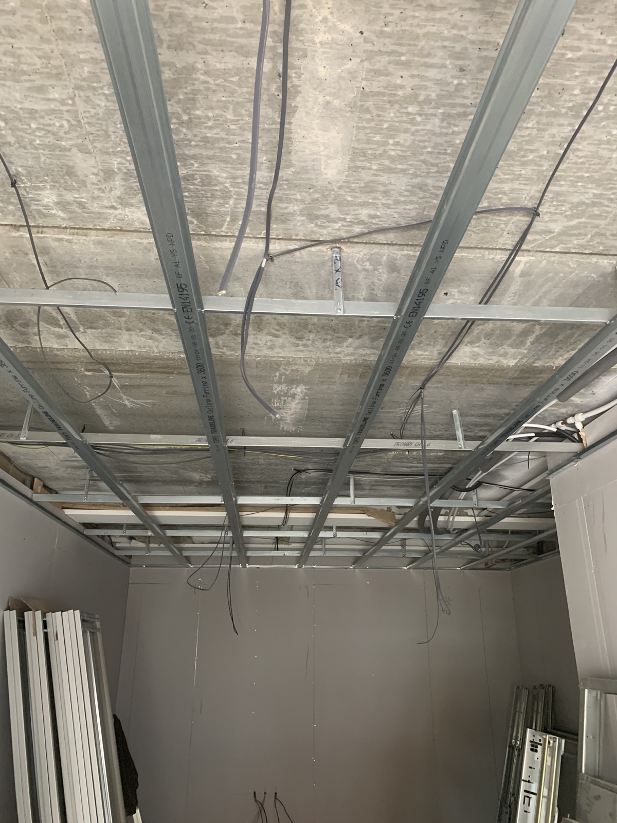 Wide view of metal ceiling framework installed below a concrete soffit