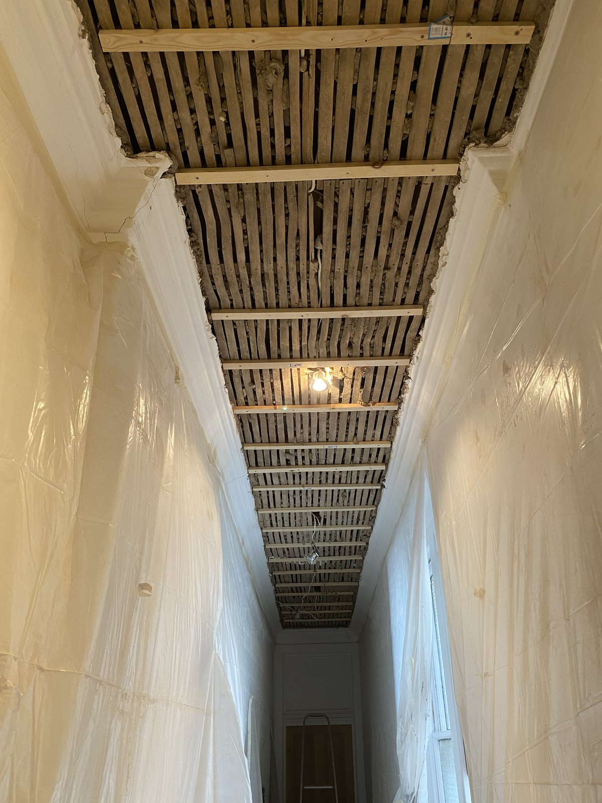 Timber grounds installed across the retained laths in the Maida Vale hallway