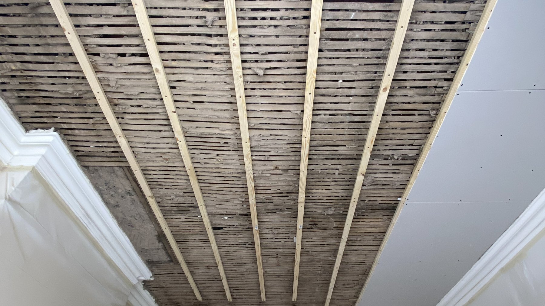 New timber fixing grid beneath a retained lath ceiling in Maida Vale