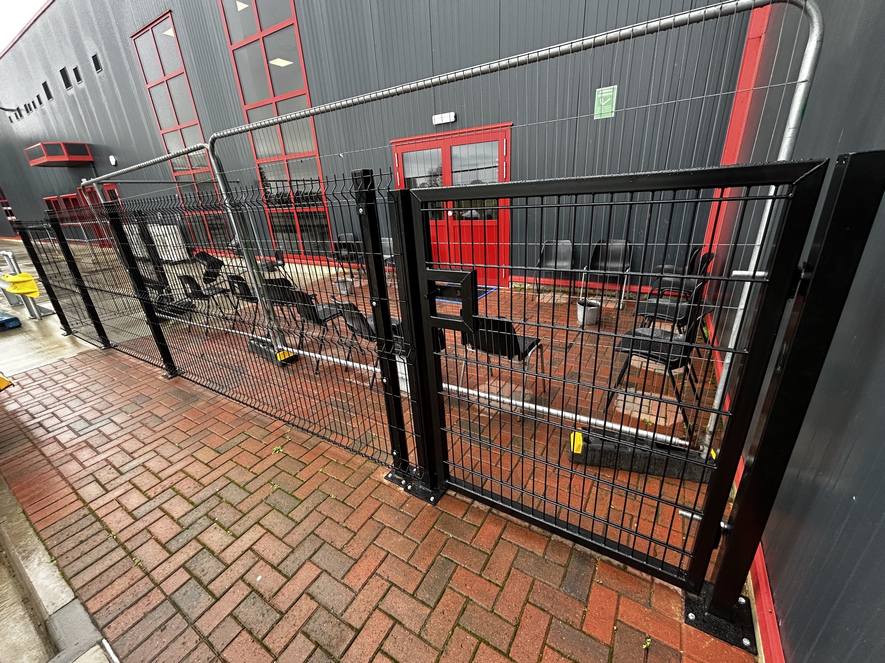 Secure black fencing and access gate around a Norwich smoking area
