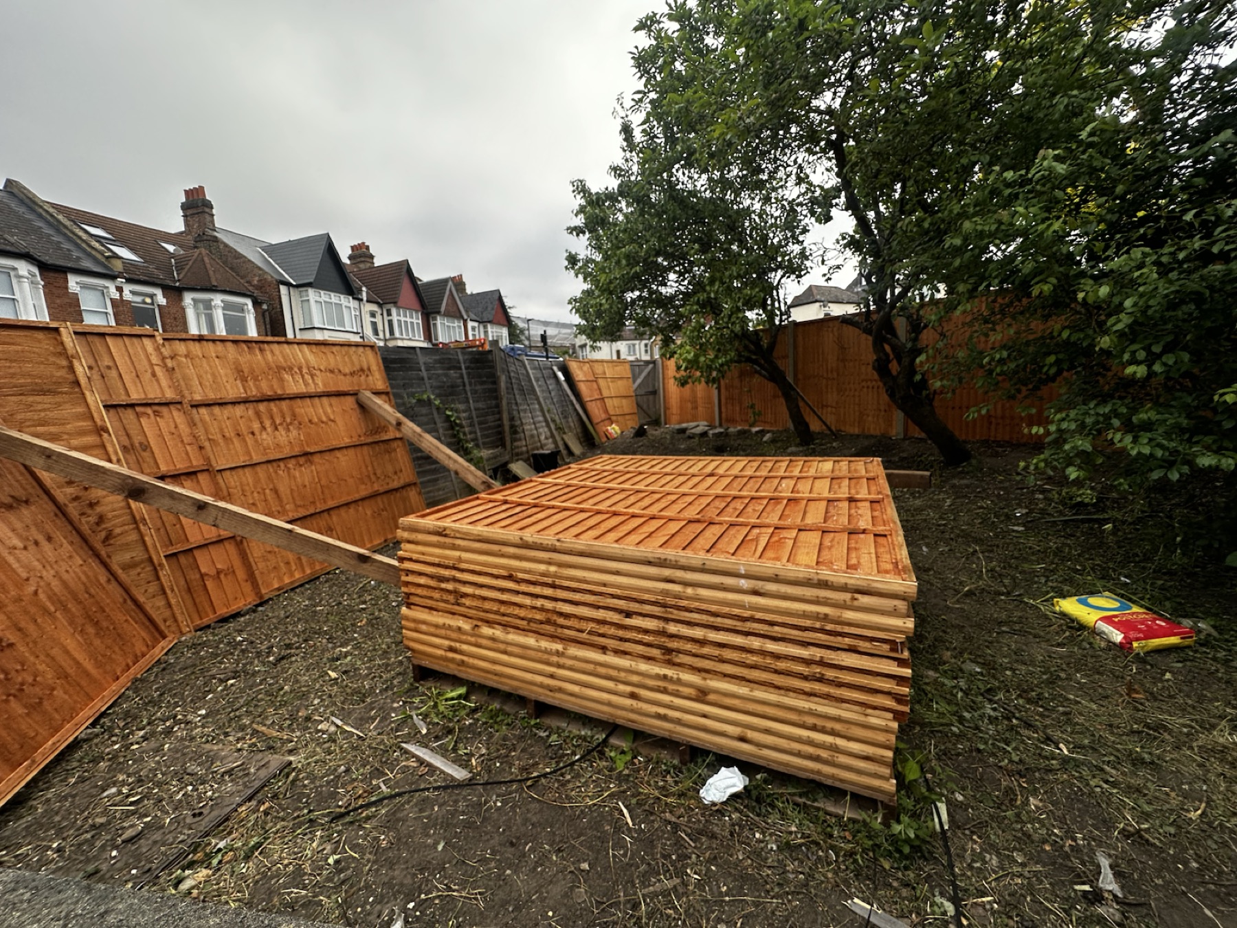 New timber fence panels stacked after delivery to the garden