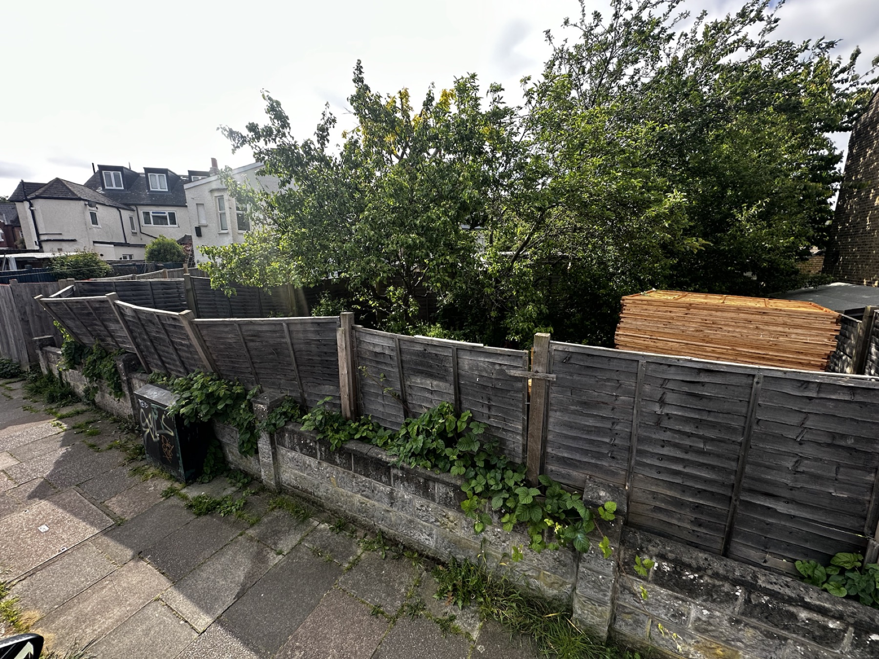 Uneven weathered timber fencing before replacement in Streatham