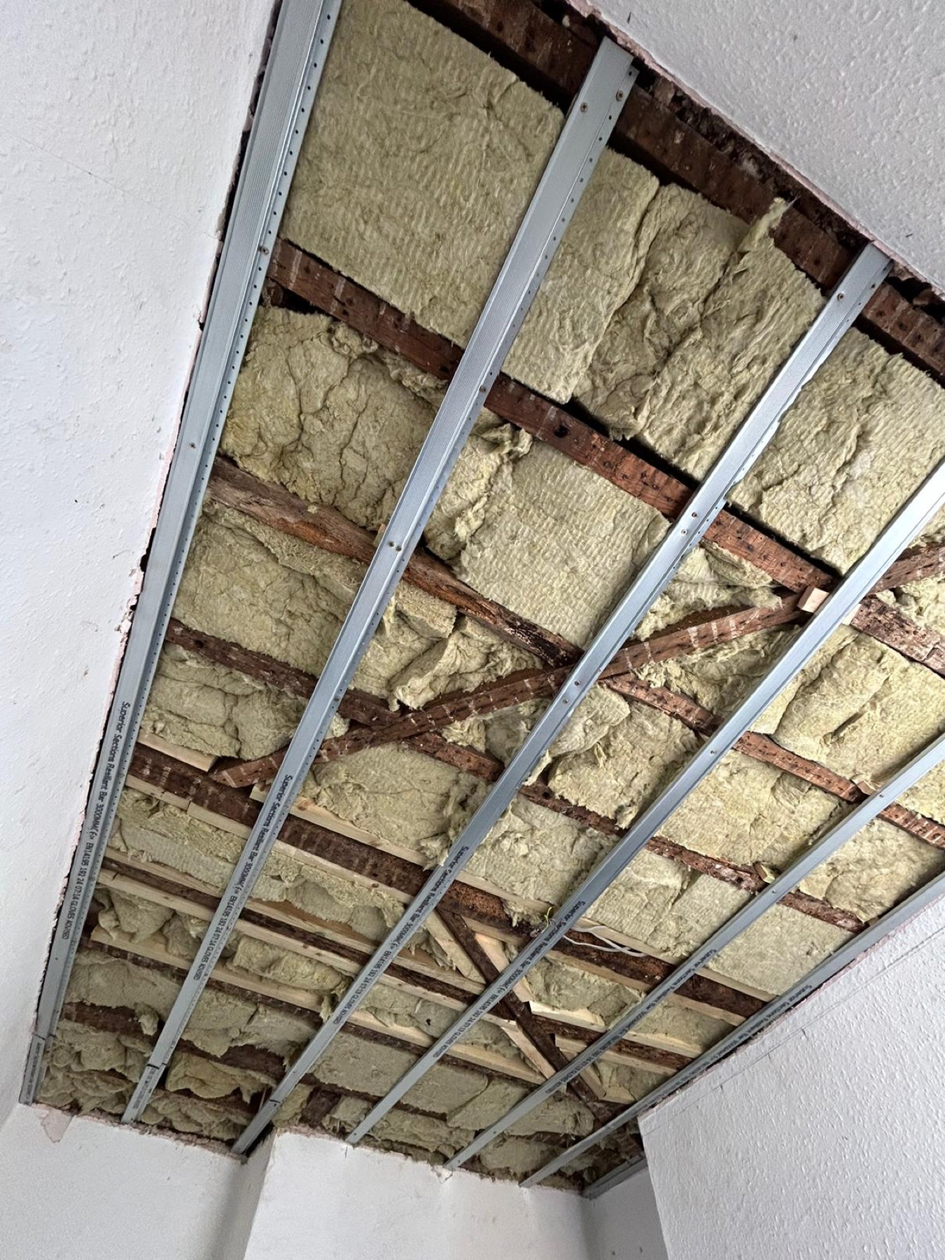 Mineral wool between timber joists with resilient bars installed below