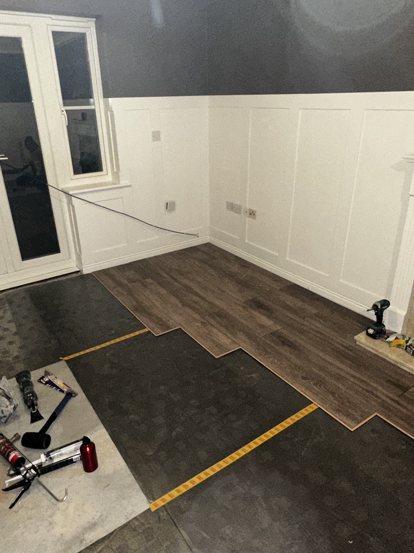 Timber-effect flooring being installed over prepared subfloor