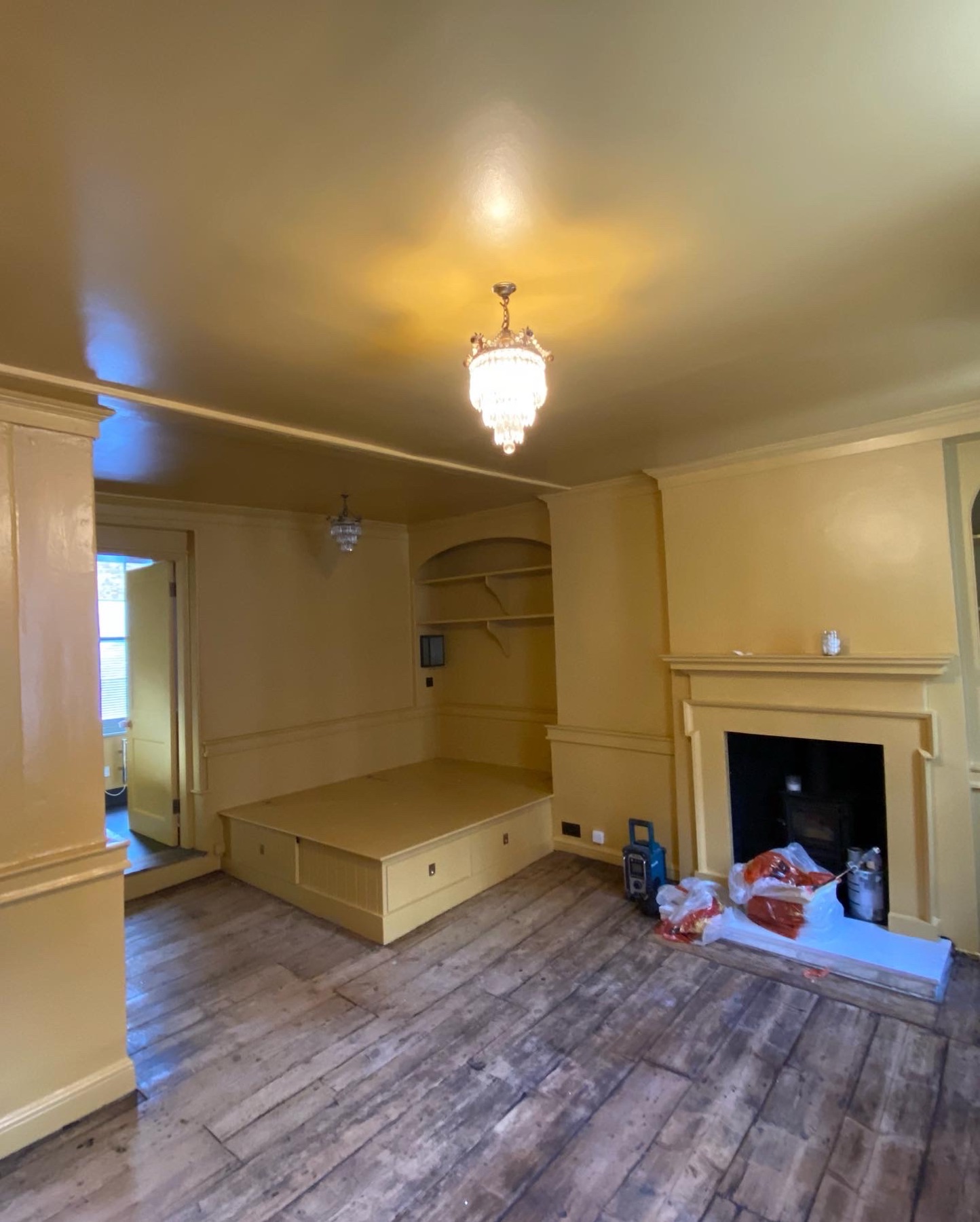 Warm Farrow and Ball painted reception room with fireplace and fitted seating