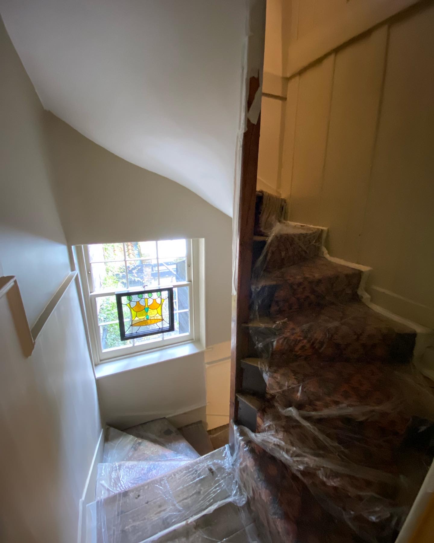 Freshly painted townhouse stairwell with stained-glass window