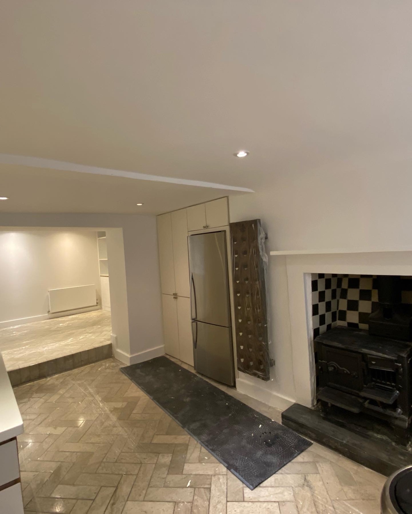 Light redecorated kitchen with stove and herringbone floor